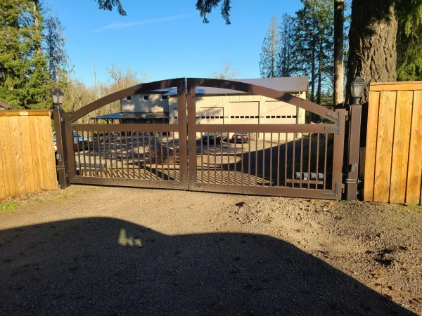 Double swing metal driveway gates with ornamental iron scrollwork