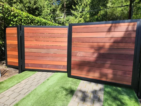 Double wooden driveway gates with natural stain finish and steel frame support