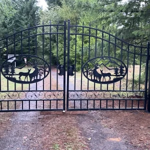 Decorative wrought iron driveway gate with arched design at residential entrance
