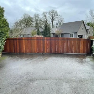 Solid panel privacy driveway gate installed between masonry columns